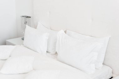 Modern Çift Kişilik Yatak odası. Bir yatakta rahat yumuşak beyaz yastıklar. İç odalar bir daire veya otel.