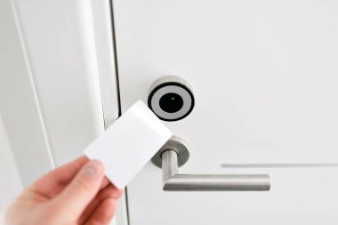 Otel kapı - bir anahtarın bir oda kapı Elektronik sensör önünde tutan genç adam.