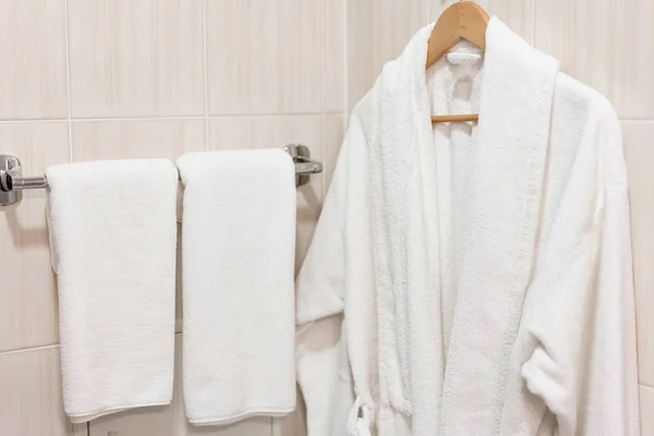 Sauberes weißes Handtuch und Bademantel auf einem Kleiderbügel bereit zu verwenden. Badezimmer im Zimmer eines Appartements oder Hotels. — Stockfoto