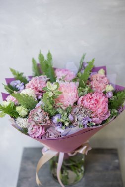 İş çiçekçi. Güzel bahar buket. Mix çiçek aranjmanı. Bir çiçekçi dükkanı, küçük bir aile şirketi kavramı. Pastel renk.