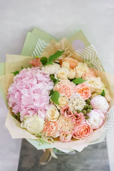 Bellissimo bouquet primaverile. composizione floreale con ortensia e peonie. Colore rosa chiaro. Il concetto di un negozio di fiori, una piccola azienda a conduzione familiare — Foto Stock
