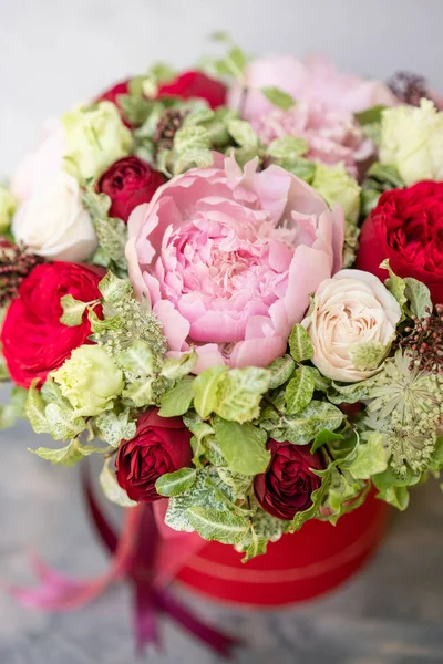 Beautiful spring bouquet in head box. Arrangement with mix flowers. The concept of a flower shop, a small family business. Red color. Work florist. — Stock Photo, Image