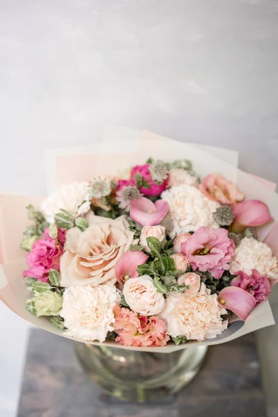 Work florist. Beautiful spring bouquet. Arrangement with mix flowers. The concept of a flower shop, a small family business. Pastel Color.