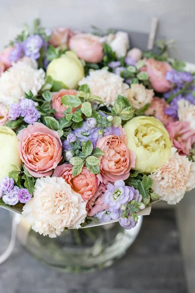 Work florist. Beautiful spring bouquet. Arrangement with mix flowers. The concept of a flower shop, a small family business. Pastel Color.