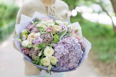 Güzel yaz buket. Mix çiçek aranjmanı. Ortanca çiçek aranjmanı tutan genç kız. Bir çiçekçi dükkanı kavramı. Katalog için içerik