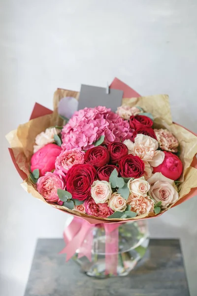 beautiful spring bouquet. flower arrangement with hydrangea and peonies. Color red and pink. The concept of a flower shop, a small family business