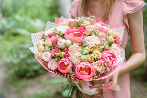 Szép nyári csokor. Elrendezése virágok mix. Fiatal girl gazdaság egy virág elrendezése a pünkösdi rózsa. A koncepció egy virágbolt. A katalógus tartalma — Stock Fotó