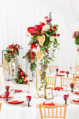 Bir düğün için bir çadır altında güzel ziyafet salonu. İç bir düğün çadırı dekorasyon misafirler için hazır. Dekor çiçek. Kırmızı Tema