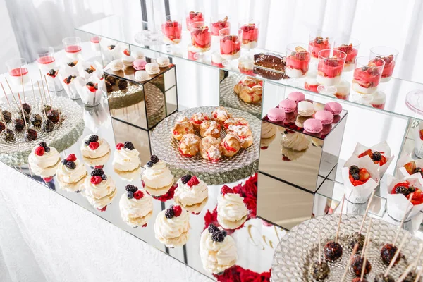 Candy bar con un sacco di dolci, meringhe, cupcake, frutta e dolci. Tavolo dolce per compleanno o matrimonio . — Foto Stock