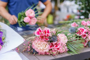 Erkek çiçekçi çiçek dükkanında güzel buket oluşturma. çiçekçide çalışan açık. Adam asistan veya sahibi çiçek tasarım Studio, dekorasyon ve düzenlemeler yapma.