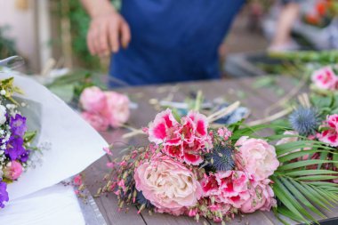 Erkek çiçekçi çiçek dükkanında güzel buket oluşturma. çiçekçide çalışan açık. Adam asistan veya sahibi çiçek tasarım Studio, dekorasyon ve düzenlemeler yapma.