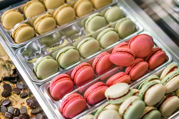 Kafe vitrin üzerinde renkli macaroons ürün yelpazesine. Macaron tatlar çeşitli. Deposundaki tatlı bademli kek.
