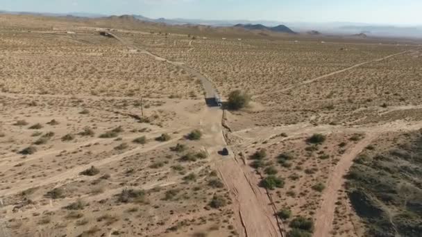 Vuelo sobre larga carretera en Monument Valley en Utah Drone Aerial sobre coches en Arizona. Imágenes de aviones no tripulados de vista superior volando sobre desierto seco y beige, sequía resultante paisaje, amenaza de calentamiento global — Vídeo de stock