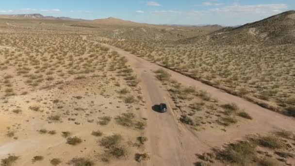 Vlucht boven lange weg in monument valley in Utah - Drone vanuit de lucht over auto's in Arizona. Top uitzicht drone beelden vliegen over droog en beige woestijn, droogte resulteerde landschap, opwarming van de aarde van bedreiging — Stockvideo