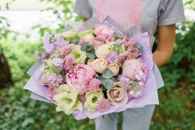 Güzel yaz buket. Mix çiçek aranjmanı. Bir çiçek grup şakayık ile tutan genç kız. Bir çiçekçi dükkanı kavramı. Katalog için içerik