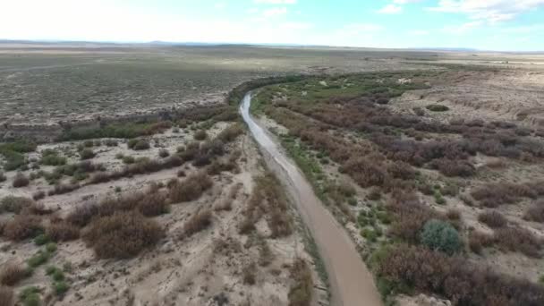 Vlucht boven lange weg in monument valley in Utah - Drone vanuit de lucht over auto's in Arizona. Top uitzicht drone beelden vliegen over droog en beige woestijn, droogte resulteerde landschap, opwarming van de aarde van bedreiging — Stockvideo