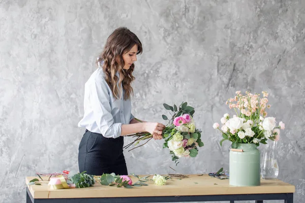 Mulher florista criando belo buquê na loja de flores. A trabalhar na florista. Assistente menina ou proprietário em estúdio de design floral, fazendo decorações e arranjos . — Fotografia de Stock