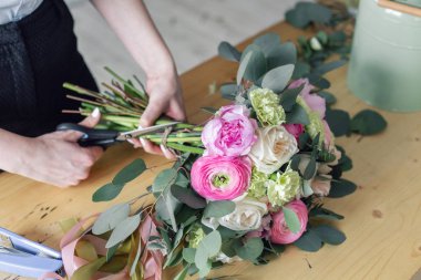 Kadın çiçekçi çiçek dükkanında güzel buket oluşturma. Çiçekçide çalışan. Kız yardımcısı veya sahibi çiçek tasarım Studio, dekorasyon ve düzenlemeler yapma.