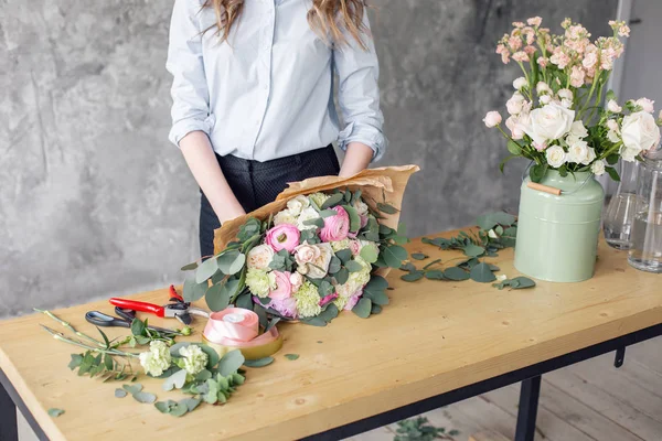 Kvinna florist skapar vacker bukett i blomsteraffär. Jobbar i blomsteraffär. Flicka assistent eller ägare i blommig designstudio, att göra dekorationer och arrangemang. — Stockfoto