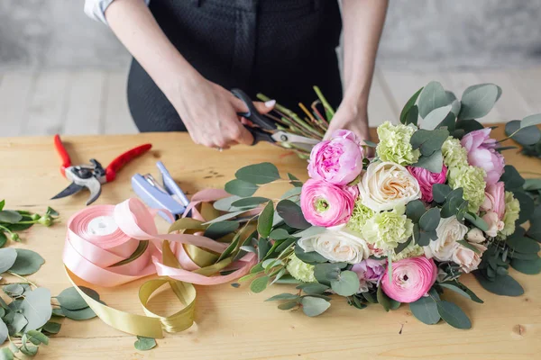 Mujer florista creando hermoso ramo en la tienda de flores. Trabajando en floristería. Asistente o propietaria en estudio de diseño floral, haciendo decoraciones y arreglos . — Foto de Stock