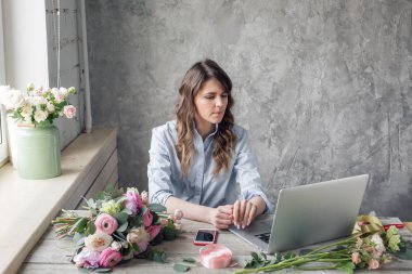 Sipariş alma ve teslim kavramı. çalışma tablosunda çiçekçi dükkanı. Kız yardımcısı veya sahibi çiçek tasarım Studio, dekorasyon ve düzenlemeler yapma.