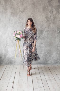 Uzun elbise genç güzel kız. Kız lüks yaz buket tutar. Kutlama veya çiçek dükkanı kavramı. kameraya bakarak