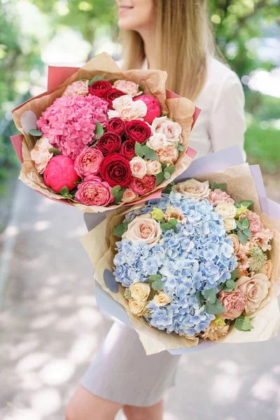 Két gyönyörű nyári csokor. Elrendezése virágok mix. Fiatal girl gazdaság egy virág elrendezése a Hortenzia. A koncepció egy virágbolt. A katalógus tartalma — Stock Fotó