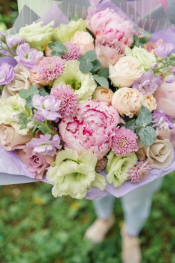 Güzel yaz buket. Mix çiçek aranjmanı. Bir çiçek grup şakayık ile tutan genç kız. Bir çiçekçi dükkanı kavramı. Katalog için içerik