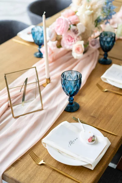 A lemez menü. Szép és gyönyörű dekoráció a lakodalomban. Bankett szolgált táblázat egy bézs rózsaszín terítő, tányérok és gyertyatartók gyertyákkal. — Stock Fotó