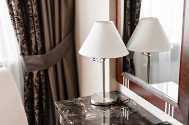iç otel daire, konforlu oda, ayna ve resepsiyon. Notlar ve bir otel odasında bir masa üzerinde duran lamba için klasör