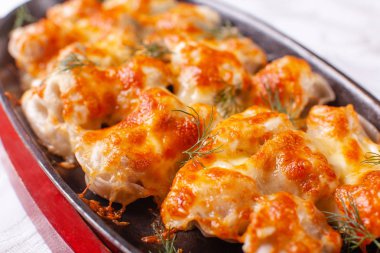 Kızarmış köfte ile soğan ve pastırma bir dökme demir tava üzerinde. erimiş peynir