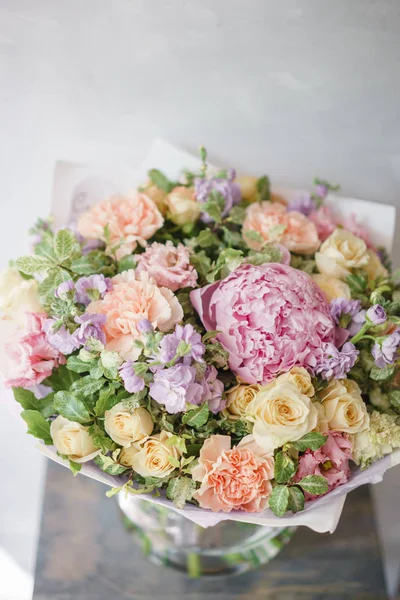 Beautiful spring bouquet. Arrangement with mix flowers. The concept of a flower shop, a small family business. Color light pink and lilac.