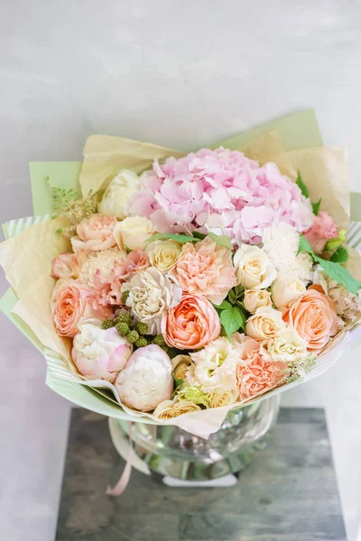 beautiful spring bouquet. flower arrangement with hydrangea and peonies. Color light pink. The concept of a flower shop, a small family business