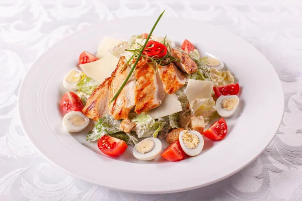 Bıldırcın yumurtası, cherry domates, Parmesan peyniri ve ızgara tavuk masa lambası beyaz tabakta, Sezar salatası. — Stok fotoğraf