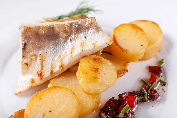 Stekt torsk, torsk med bakad potatis och grönsaker med picklad gurka och örter sås på en vit bakgrund restaurang som serverar. Restaurangmeny — Stockfoto