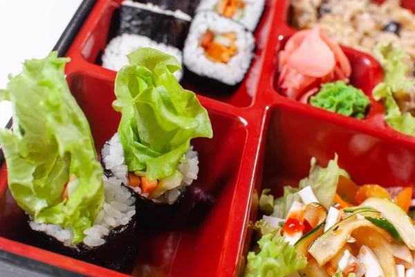 Fresh food portion in japanese bento box with salad, main course. Sushi roll with vegetables. Vegetarian dish. — Stock Photo, Image