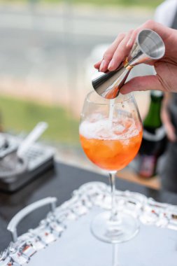 Barmen kokteyl Aperol spritz yapar. Cam, seçici odak buğulu. Alkollü içecek bar counter buz küpleri ve portakal dayalı. dış taraf