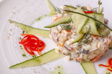 Rus geleneksel Olivier ile salata sebze ve et. Tablo üzerinde beyaz bir tabak salataya. Restoran menü