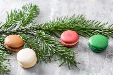 Neşeli Noel kartı. Çeşitli tatlı macaroons ve çam dalları gri antika arka plan üzerinde. Yeni yıl ruh hali
