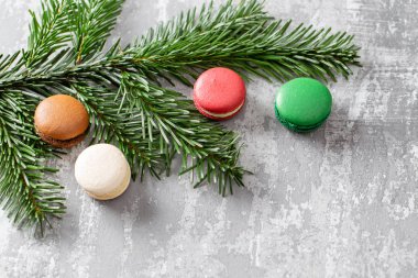 Neşeli Noel kartı. Çeşitli tatlı macaroons ve çam dalları gri antika arka plan üzerinde. düz yatıyordu, en iyi görünüm. Yeni yıl ruh hali
