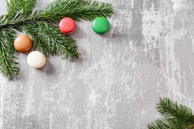 Neşeli Noel kartı. Çeşitli tatlı macaroons ve çam dalları gri antika arka plan üzerinde. düz yatıyordu, en iyi görünüm. Yeni yıl ruh hali