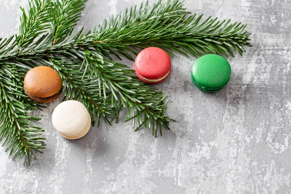 Neşeli Noel kartı. Çeşitli tatlı macaroons ve çam dalları gri antika arka plan üzerinde. düz yatıyordu, en iyi görünüm. Yeni yıl ruh hali