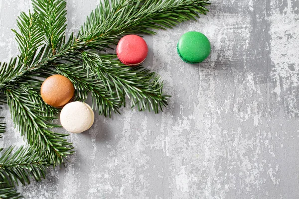 Neşeli Noel kartı. Çeşitli tatlı macaroons ve çam dalları gri antika arka plan üzerinde. düz yatıyordu, en iyi görünüm. Yeni yıl ruh hali