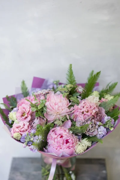 Work florist. Beautiful spring bouquet. Arrangement with mix flowers. The concept of a flower shop, a small family business. Pastel Color.