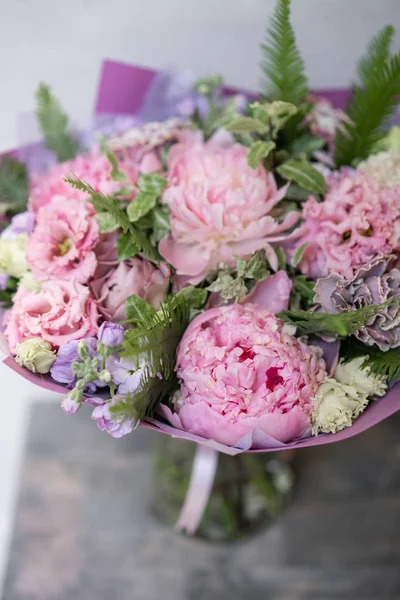 Floristin arbeiten. schöner Frühlingsstrauß. Arrangement mit Mischblumen. das Konzept eines Blumenladens, eines kleinen Familienunternehmens. Pastellfarbe. — Stockfoto
