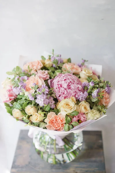 Hermoso ramo de primavera. Arreglo con flores de mezcla. El concepto de una floristería, un pequeño negocio familiar. Color rosa claro y lila . —  Fotos de Stock