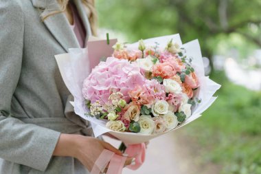 Güzel yaz buket. Mix çiçek aranjmanı. Ortanca çiçek aranjmanı tutan genç kız. Bir çiçekçi dükkanı kavramı. Katalog için içerik