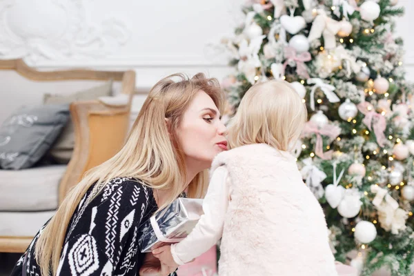 Veselá maminka objímá její roztomilé dcerušky. Rodič a dítě baví poblíž vánoční stromeček doma. Milující rodiny Veselé Vánoce a šťastný nový rok — Stock fotografie