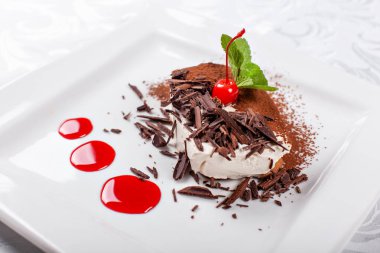 Tiramisu. Kakao ve çikolata beyaz kare plaka ile klasik tatlı. Kiraz ve nane ile süslenmiş. Şekerli tatlı restoranda. Sabah güneşi