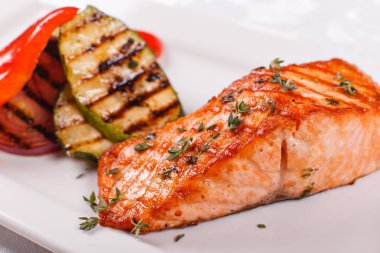 Kırmızı sıcak ve baharatlı fileto balık. Izgara biftek somon veya alabalık ızgara kırmızı biber ve kabak ile. Sağlıklı gıda, deniz ürünleri ve sebze.